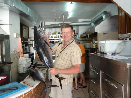 официант пригласил нас на кухню, чтобы мы посмотрели на работу поваров и сфотографировались с рыбой