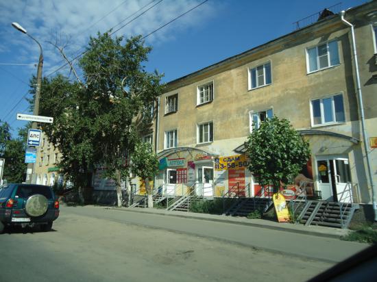 В городе старые дома. На первых этажах везде магазины.